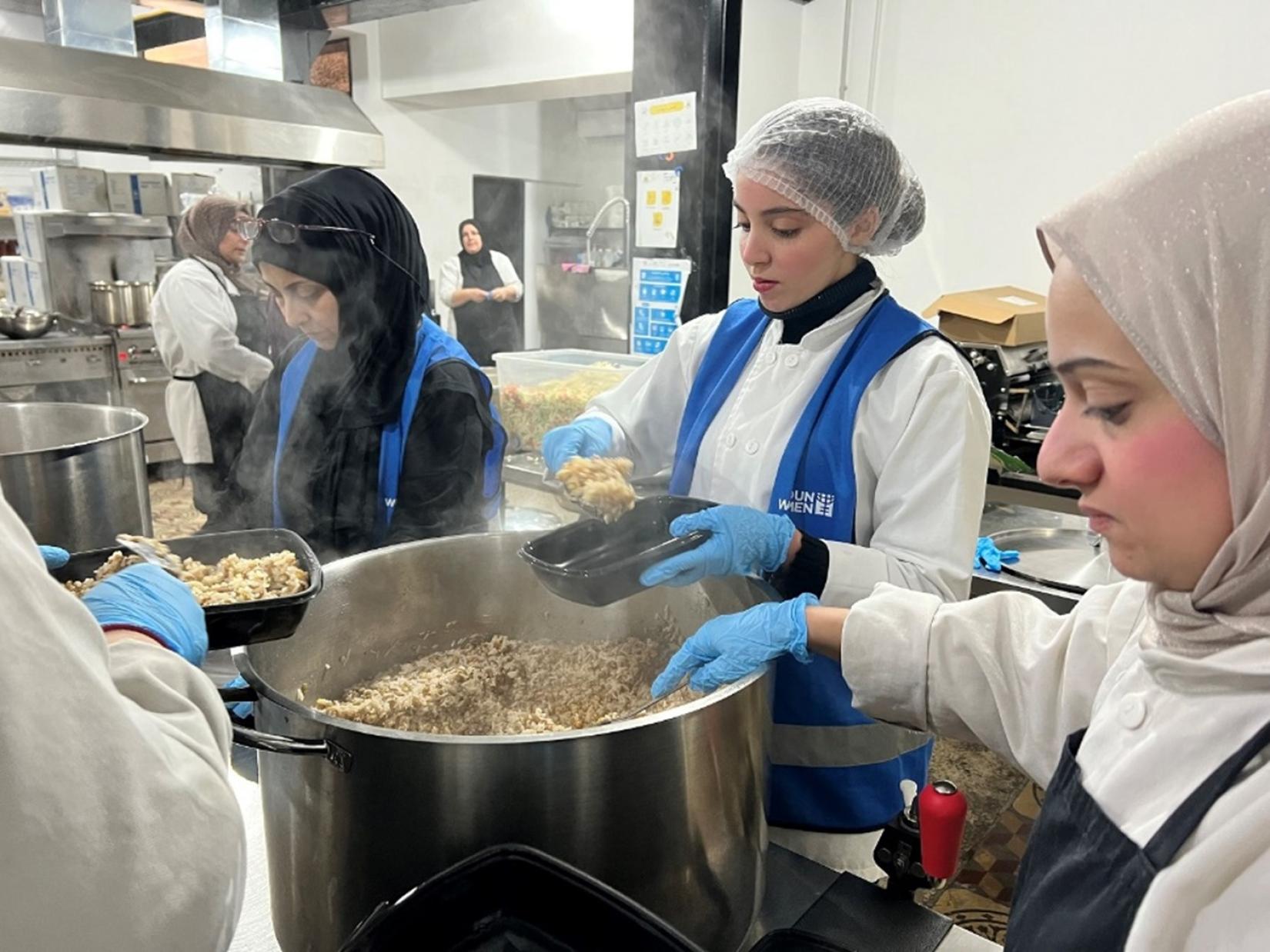 Riwa Hattab (center) with her teammates preparing warm meals for people in need at Access Kitchen. 