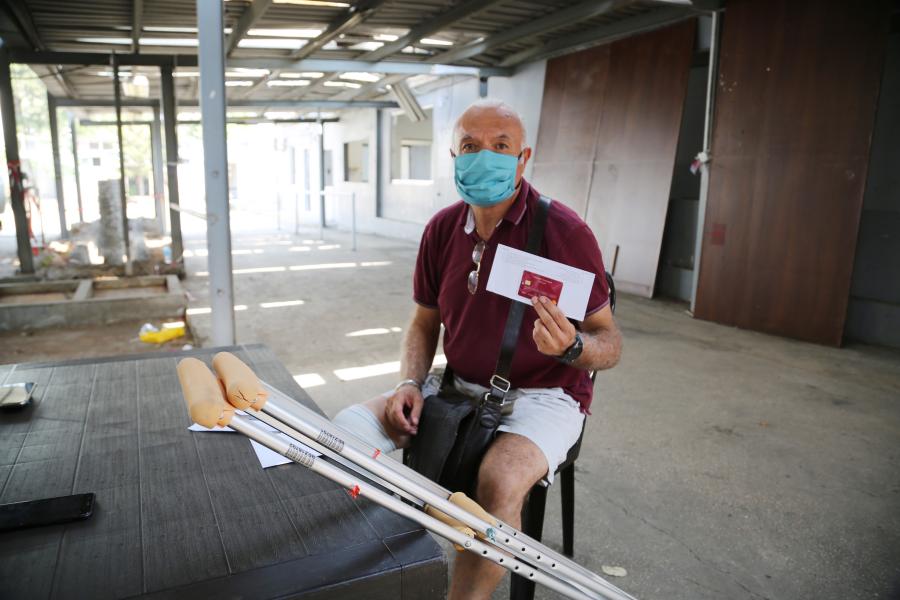 A man injured by the blast receives cash assistance from WFP